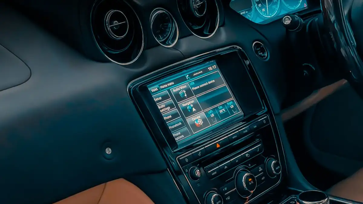 Close-up interior mobil mewah yang menampilkan dashboard, kontrol, dan layar sentuh.