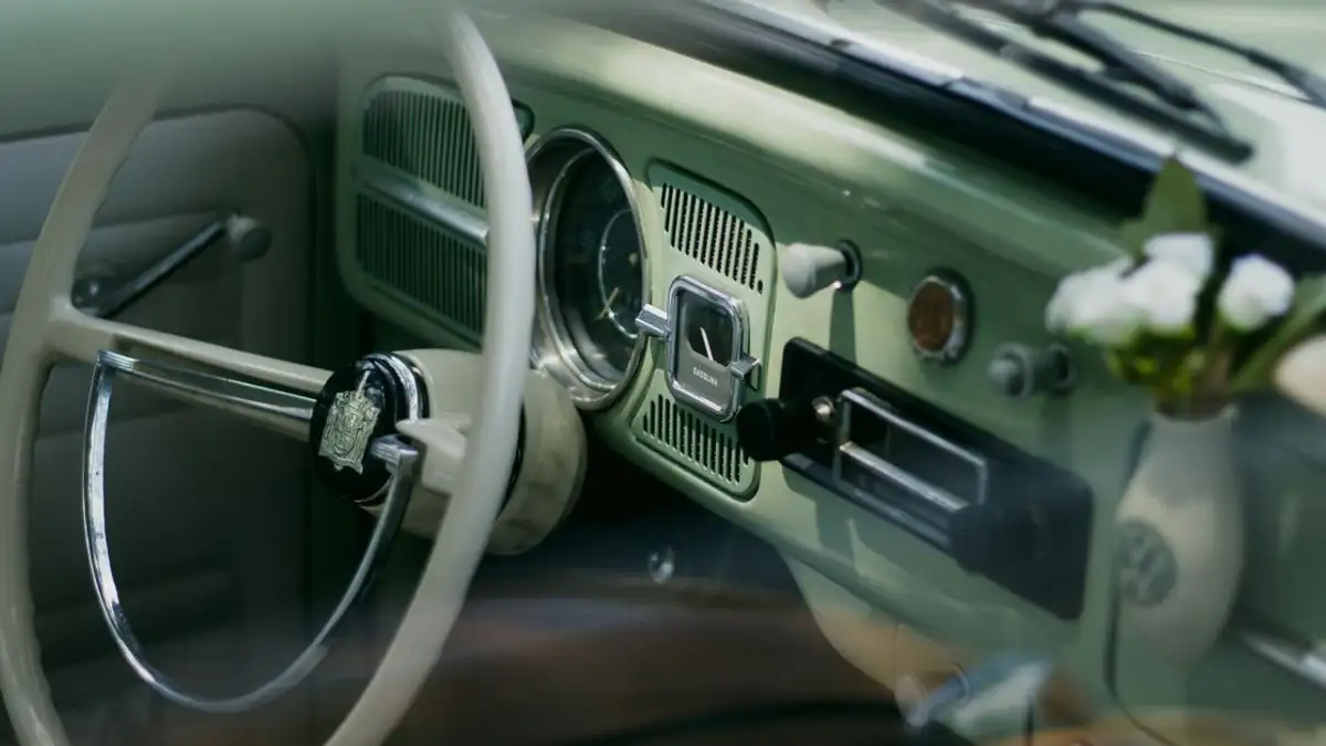 Tampilan dekat dasbor mobil klasik dengan elemen desain retro dan setir.