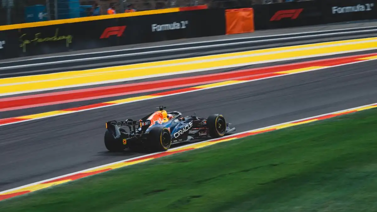 Mobil Formula 1 berkecepatan tinggi di Sirkuit Spa-Francorchamps di Stavelot, Belgia, pada hari balapan yang cerah.