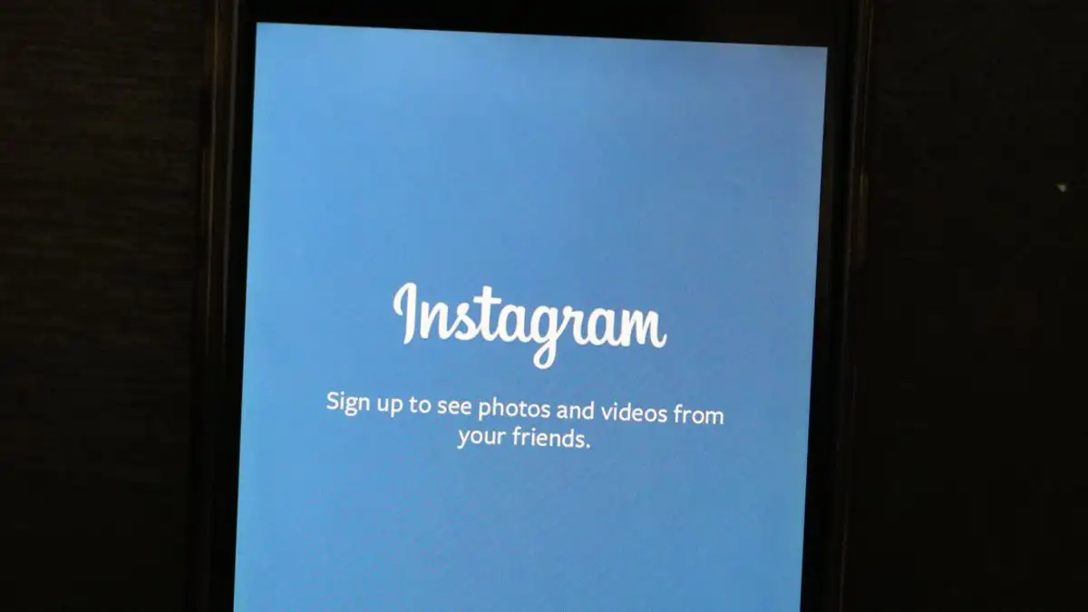 Dekat pada smartphone yang menampilkan layar selamat datang aplikasi Instagram, mengundang pengguna untuk mendaftar.